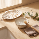 Cleaning gold necklaces, hoop earrings and a silver bracelet with a soft brush, a bowl of water and a soft cloth