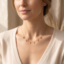 Woman wearing a gold name necklace with letter charms