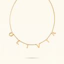 Gold name necklace with letter charms spelling OLIVIA on ivory background