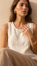 Woman wearing layered gold necklaces, gold rings and bangles