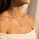 Layered gold necklaces with pearl and coin pendants